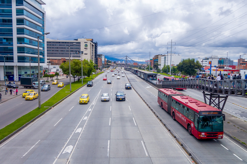 BOGOTA, COLOMBIA - FEBRUARY 9, 2015: Great overview shot of main road portraing red public transportation Transmilenio, background brick urban buildings from Bogota Colombia